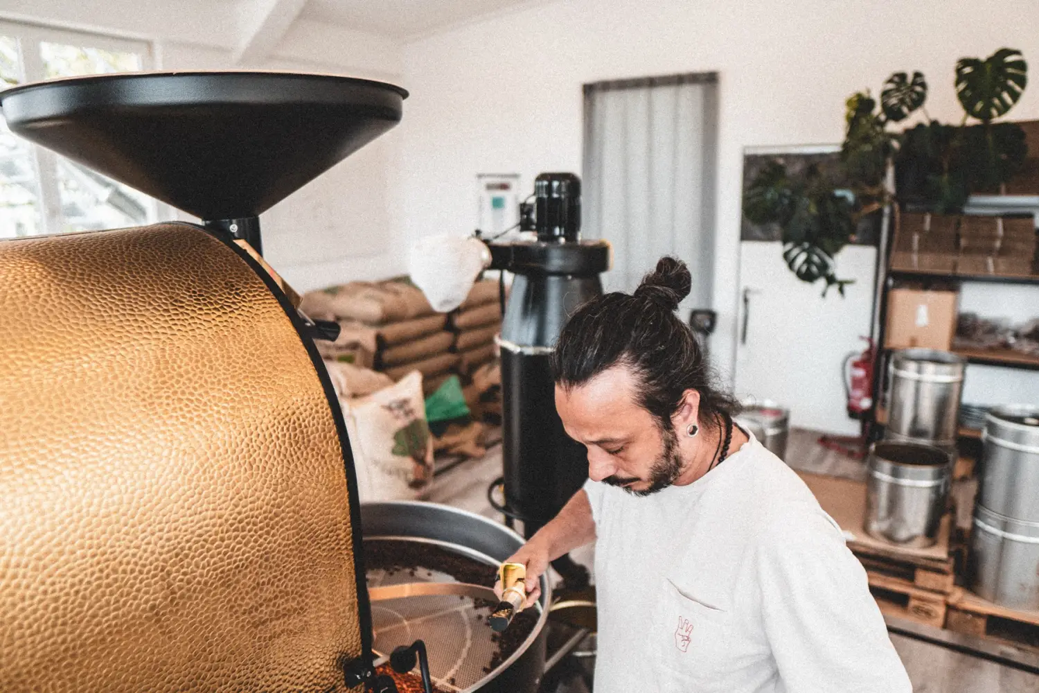 Gian Zaniol an der gold-schwarzen Röstmaschine im hellen Loft-Raum